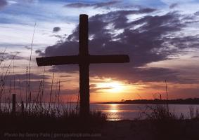 The sun sets on Barrier Island where crosses made from Palmetto trees line the dunes.