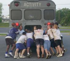 Players push a bus through the parking lot at Byrnes' Breakfast of Champions earlier this week. The Breakfast of Champions is a four-day program that includes team-building exercises in an effort to bond players.