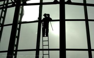 Carlos Campos of Kapasi Glass Mart removes  glass out of this broken section in preparation of putting in a new one Wednesday Feb. 19, 2003 at the BMW Zentrum in Greer S.C. The reason for the broken section of tinted window was unknown.(AP Photo/Spartanburg Herald Journal/Gerry Pate)